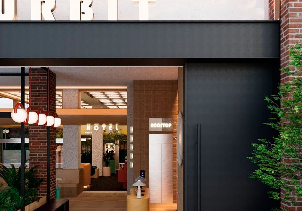 Entrada del hotel Ibis Styles Medellín en The Urbit Hub con diseño moderno y señalización hacia el rooftop