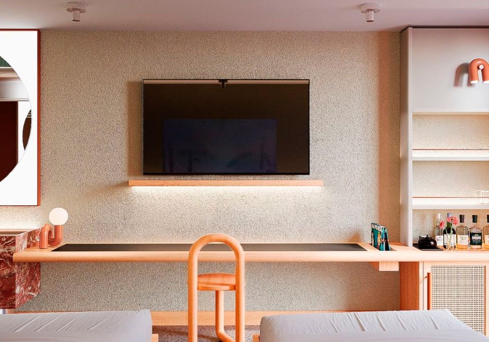 Habitación moderna con televisor, escritorio y minibar en el hotel Ibis Styles Medellín