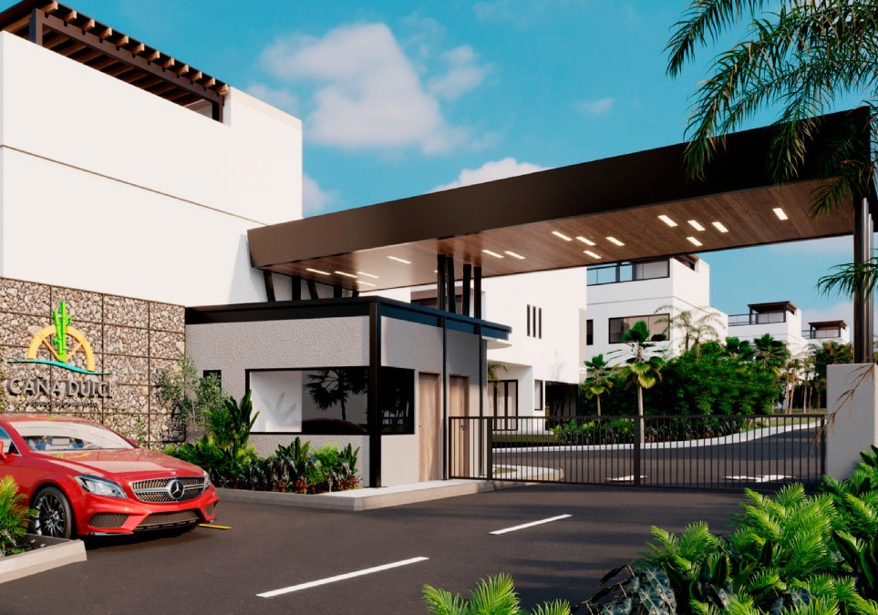 Portería principal del proyecto Caña Dulce con acceso vehicular, seguridad privada y diseño moderno rodeado de naturaleza.